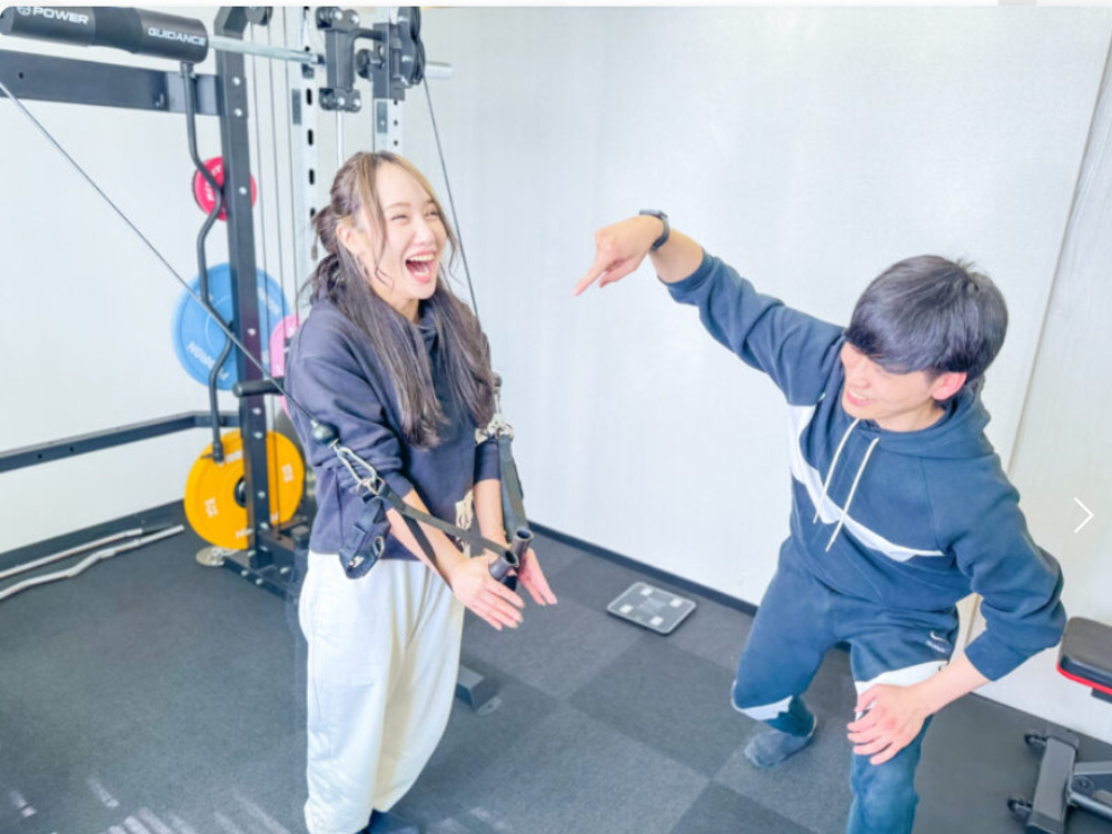 リアルボディジムにて女性が楽しくパーソナルを受けている写真