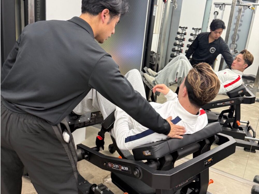 山崎トレーナーがヒップスラストを教えている写真