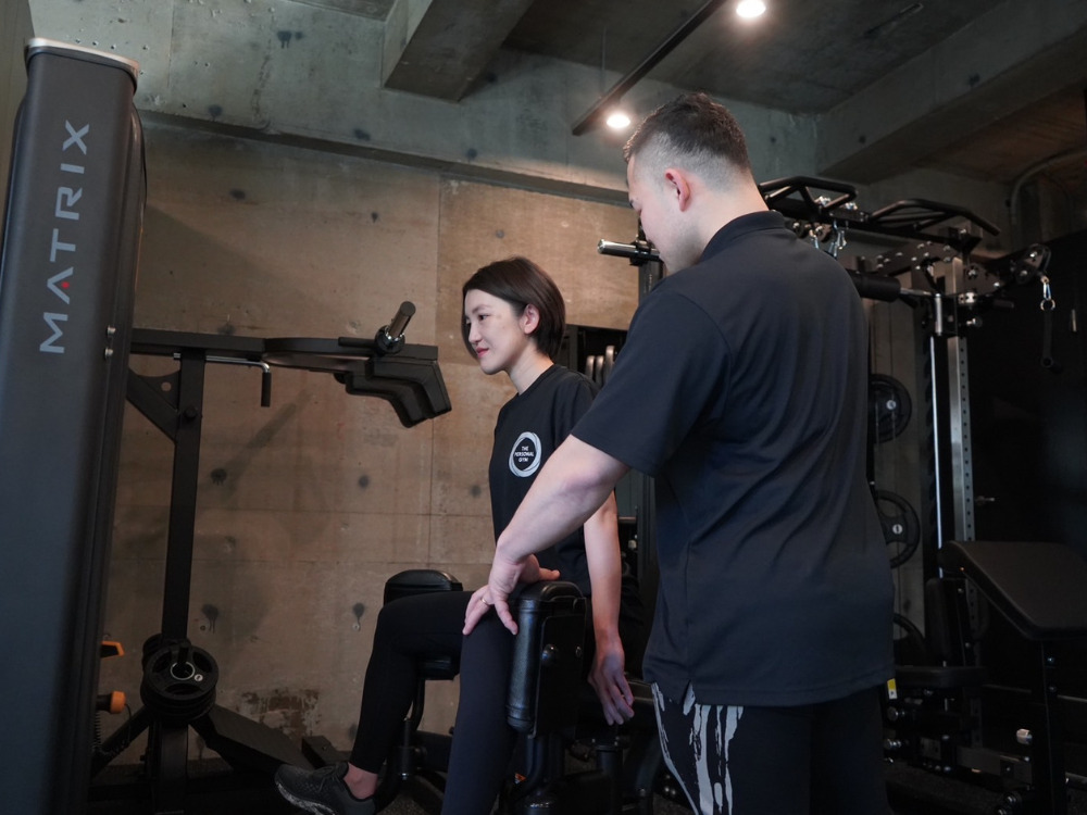 THE PERSONAL GYM（ザ 　パーソナルジム）綾瀬店でトレーニングしている女性１名と男性トレーナー１名