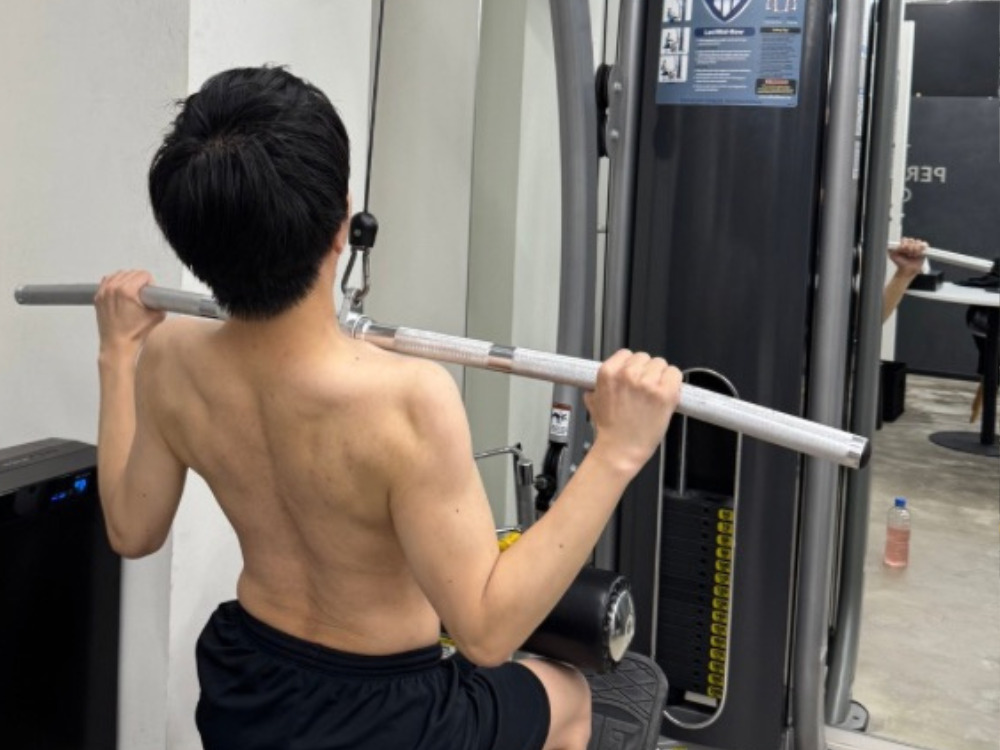 男性がラットプルダウンをしている写真