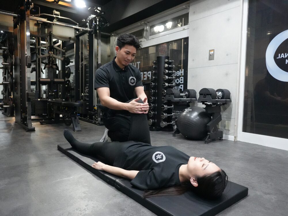 トレーナーがお客様をストレッチ&ケアしている様子