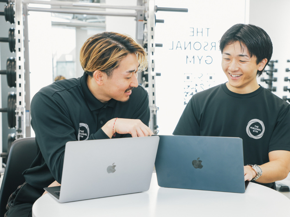 男性トレーナー2名がPCを見て話し合っている写真