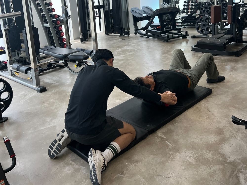 トレーナーがお客様をストレッチさせている画像