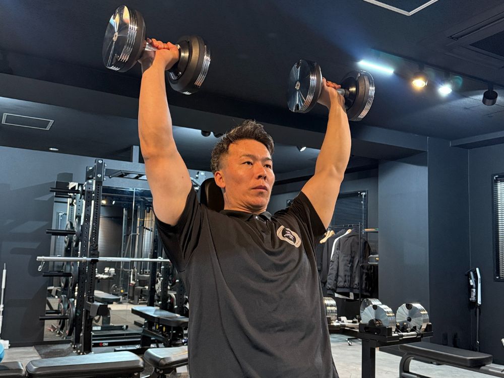 江東区門前仲町のパーソナルジムで萩原トレーナーが肩トレーニングを行っている場面