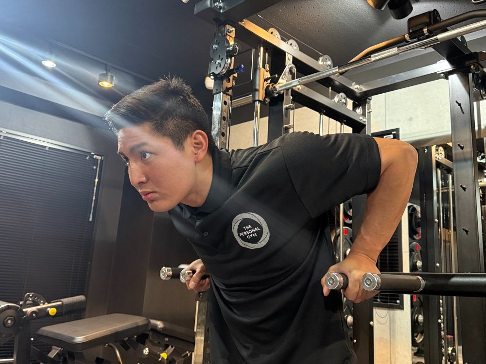 門前仲町のパーソナルジムにて、小泉トレーナーがマンツーマンでパーソナルトレーニングを指導している風景