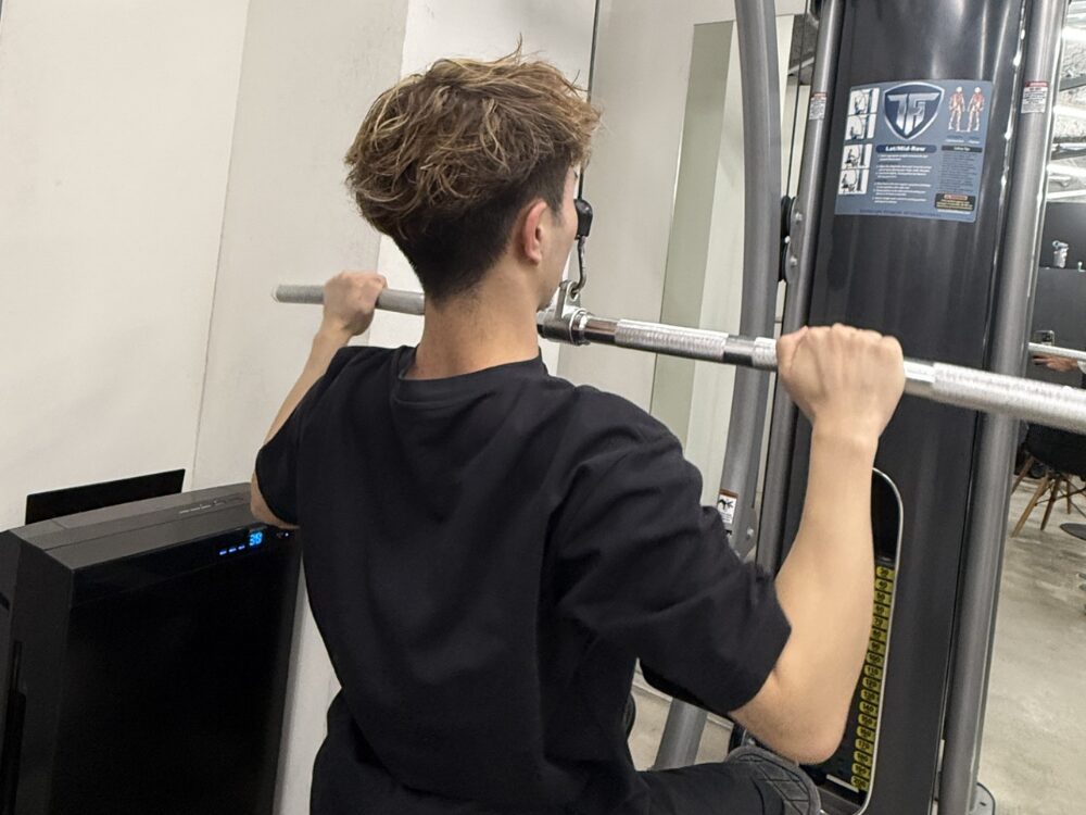 男性がラットプルダウンをしている写真