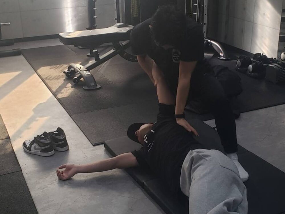 小西トレーナーが、お客様の関節の可動域（ROM）を医療的視点で厳密に測定し、現在の身体の「錆びつき」をロジカルに説明しているシーン