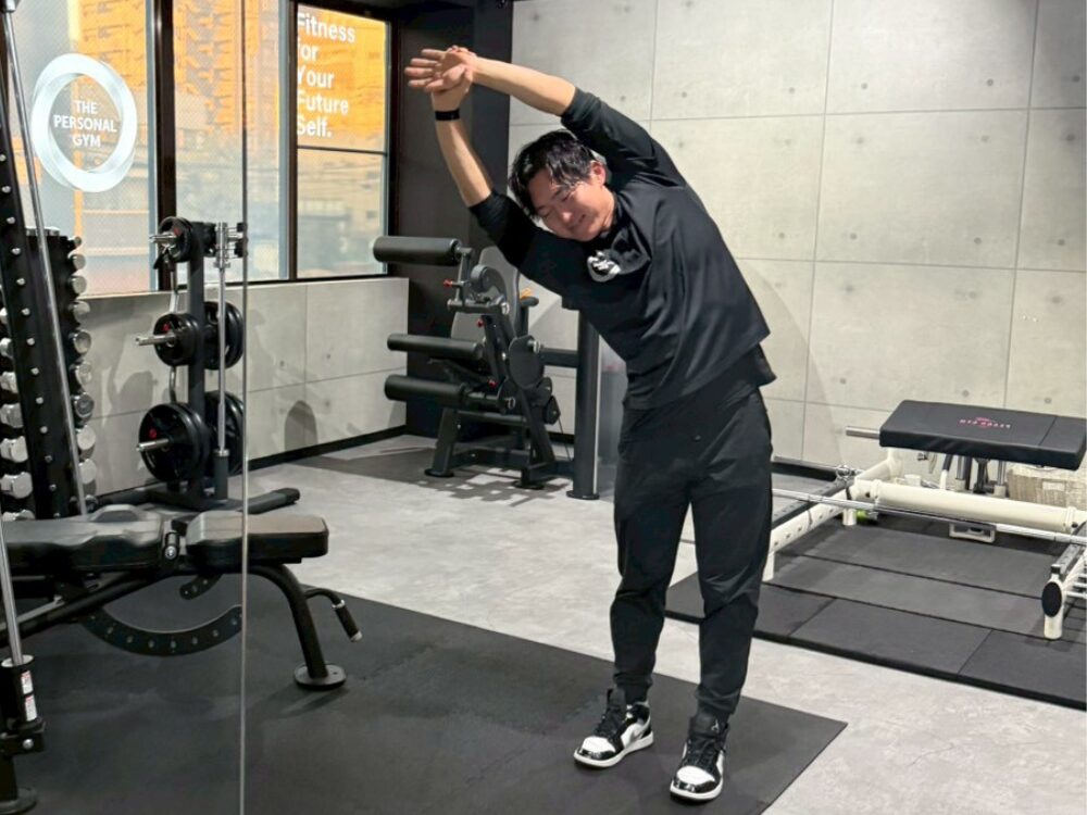 自宅で再現可能な、ストレッチフォームを、小西トレーナーが解剖学的に解説しながら実演している様子