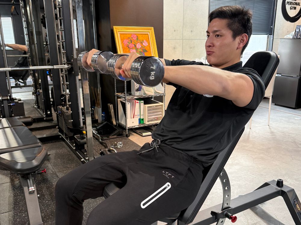 明るく清潔感のあるTHE PERSONAL GYM 門前仲町店のジム内で、小泉トレーナーがトレーニング指導をしている場面