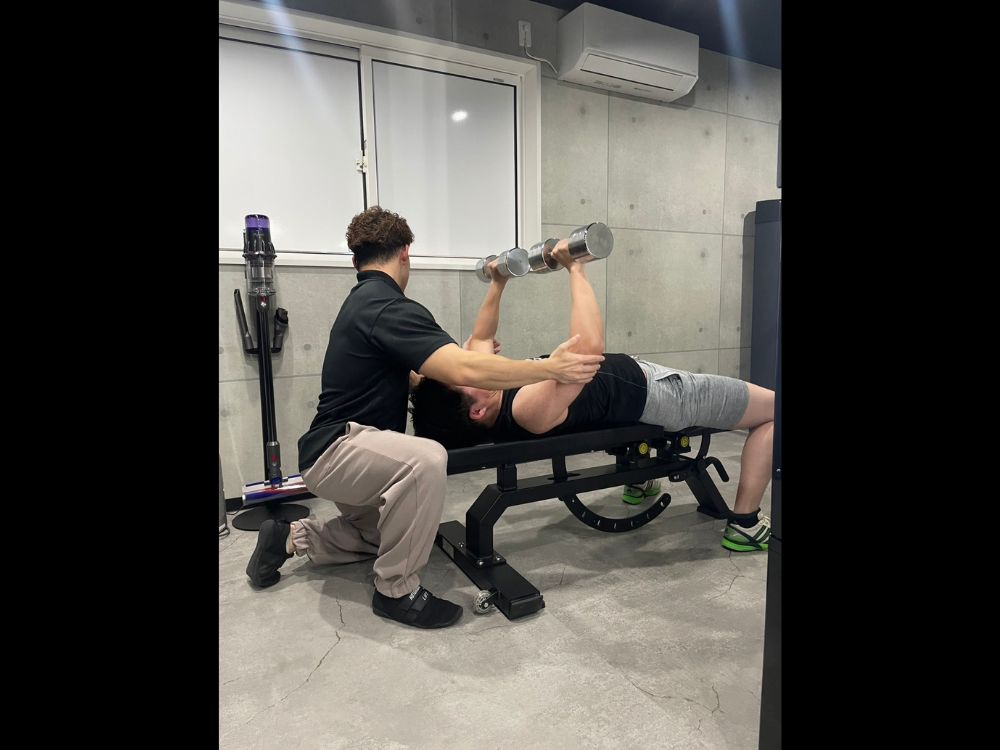 大宮のパーソナルジムで正しいフォームをサポートするトレーニング指導の様子