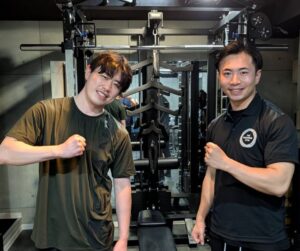 トレーナーとお客様がマシン前でポーズしている