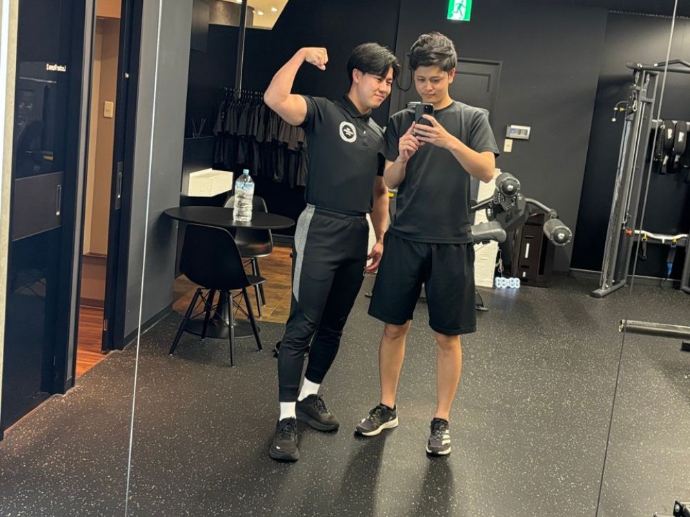 お客さんと写真を撮るトレーナー伊藤