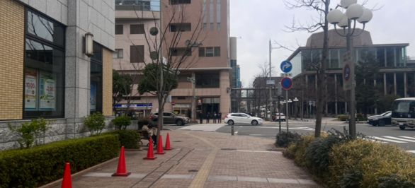  信号は渡らずに左折してください。20mほど踏み切りの方に向かうと、茶色のビルが見えます。