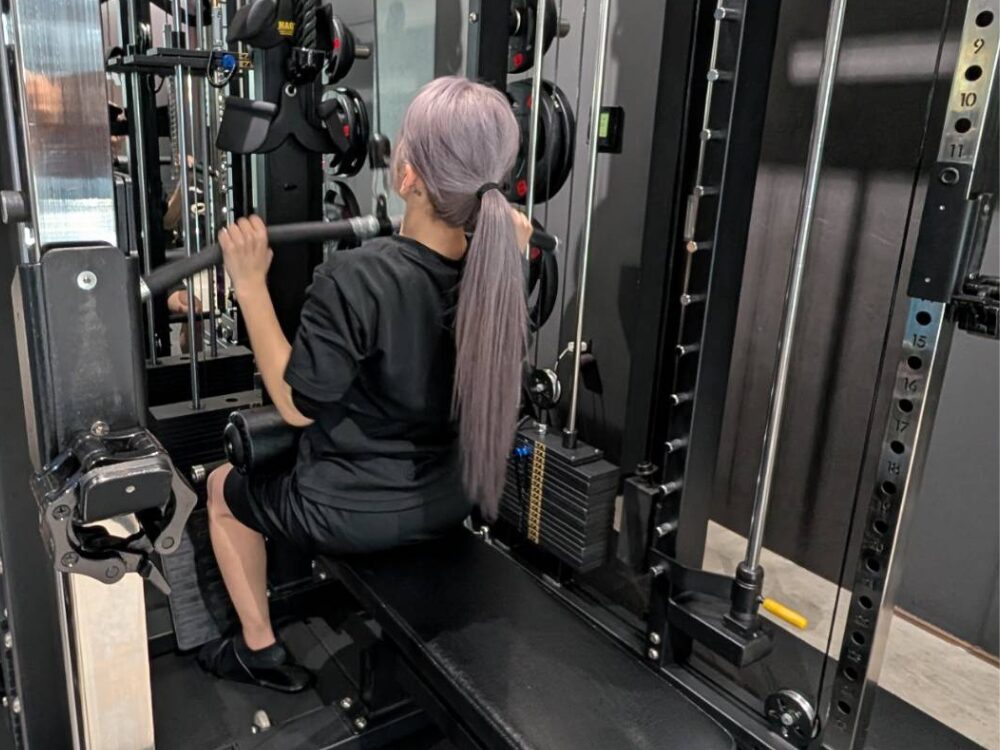 背中のトレーニングであるラットプルダウンをしている様子