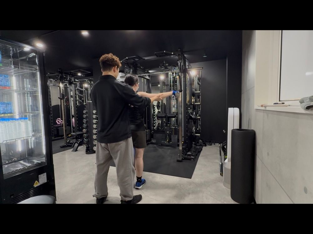 大宮のパーソナルジムでトレーナーのサポートを受けながらトレーニングする様子