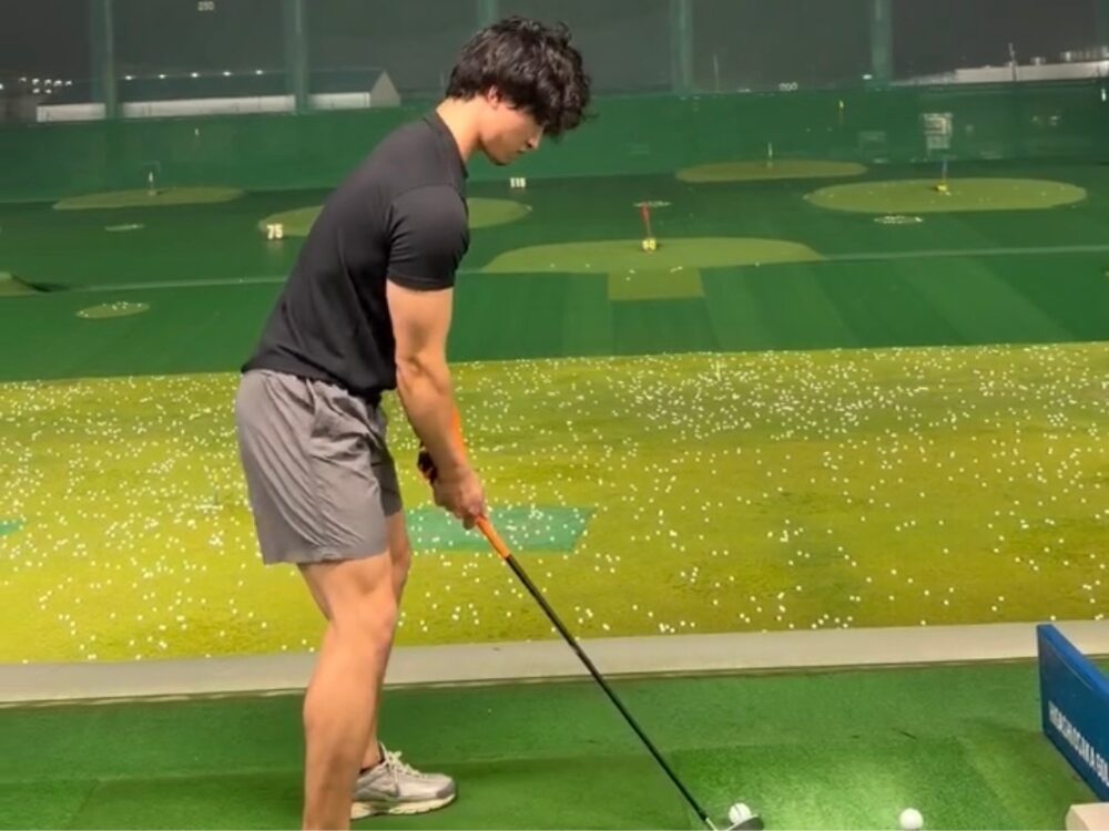 ゴルフの練習中の足立トレーナー