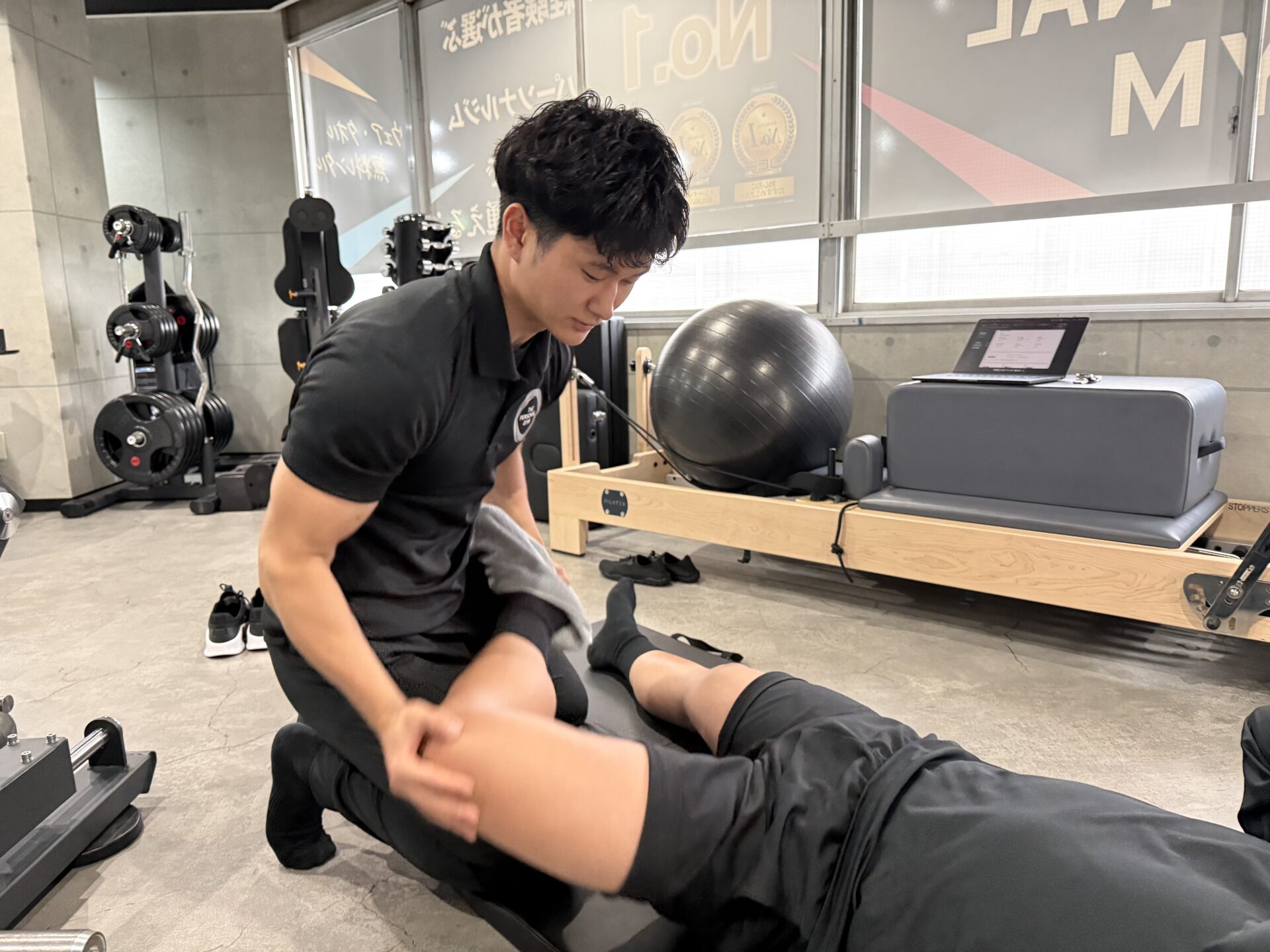 THE PERSONAL GYMあま市甚目寺店でストレッチを行うトレーナー稲垣