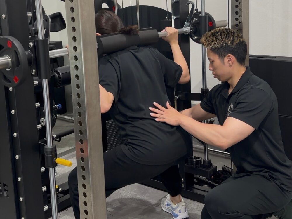 下井草駅・鷺ノ宮駅から通いやすいTHE PERSONAL GYM（ザパーソナルジム）下井草店のお客様がスミスマシンでワイドスクワットを行ってお尻の筋肉を鍛えている写真