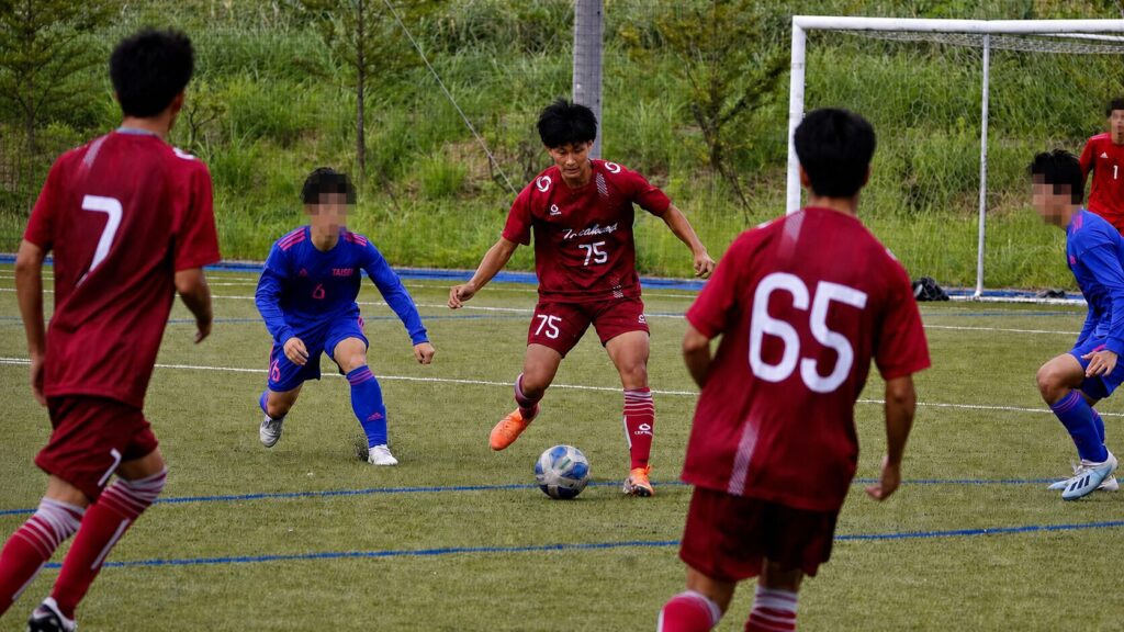 試合中にボールを運ぶ稲垣トレーナー（周囲の選手をモザイク加工済み）