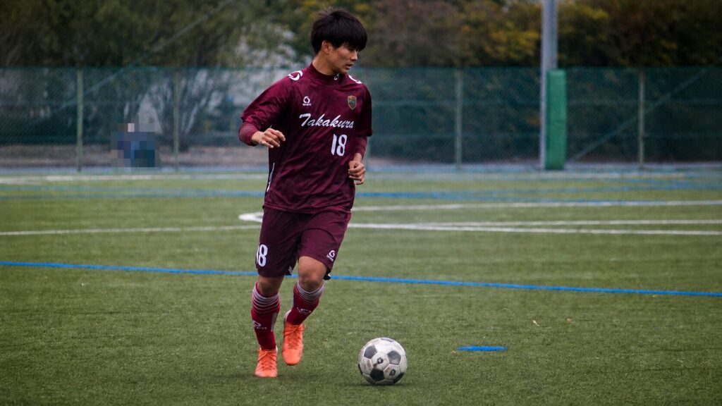 サッカーの試合でボールを運ぶ稲垣トレーナー（背景人物をモザイク加工済み）