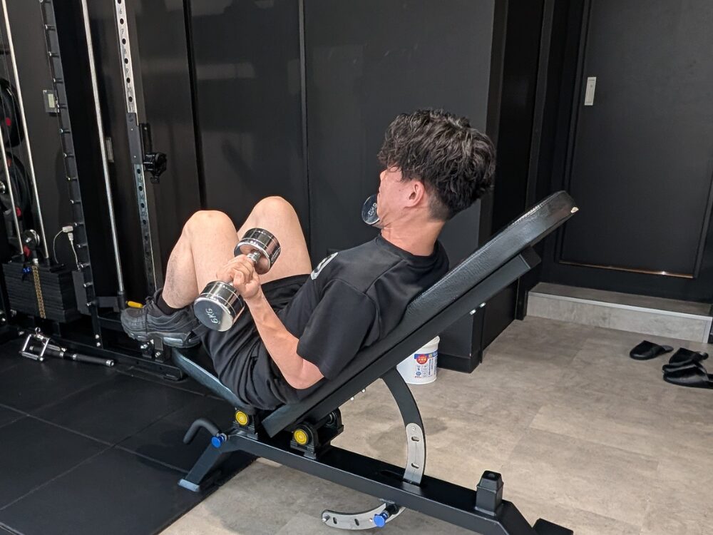 お客様がインクラインダンベルカールをしている様子