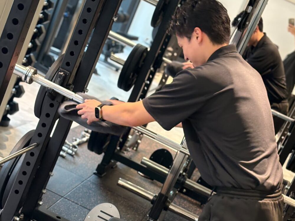 トレーナーが器具の清掃を行っている写真